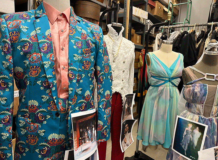 A photo shows three colorful costumes that have been hung on mannequins for display, along with photos of the dramatic production that each costume appeared in.