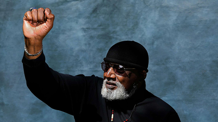 harry edwards holds his fist in the air to express solidarity and power